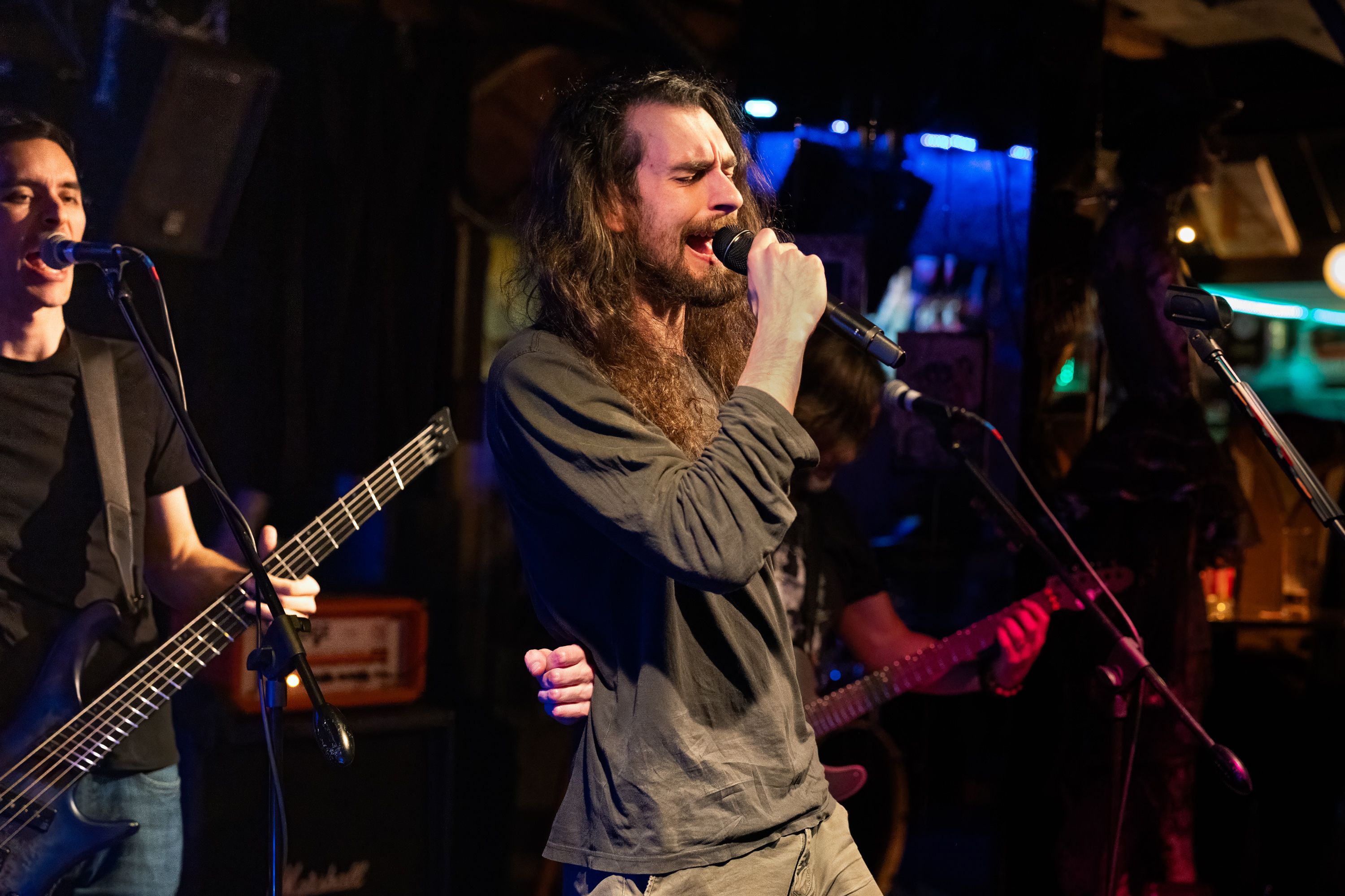 Philippe Nix singing and playing guitar live on stage.
